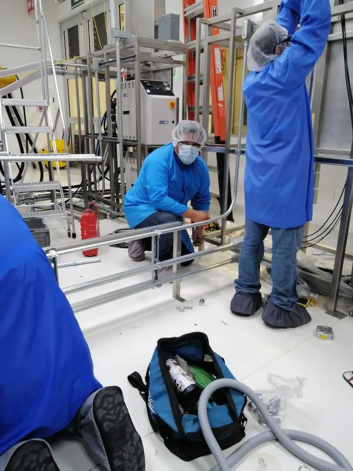 Ingenieros ejecutando pruebas de calidad de energía con analizador trifásico sobre tablero eléctrico didáctico